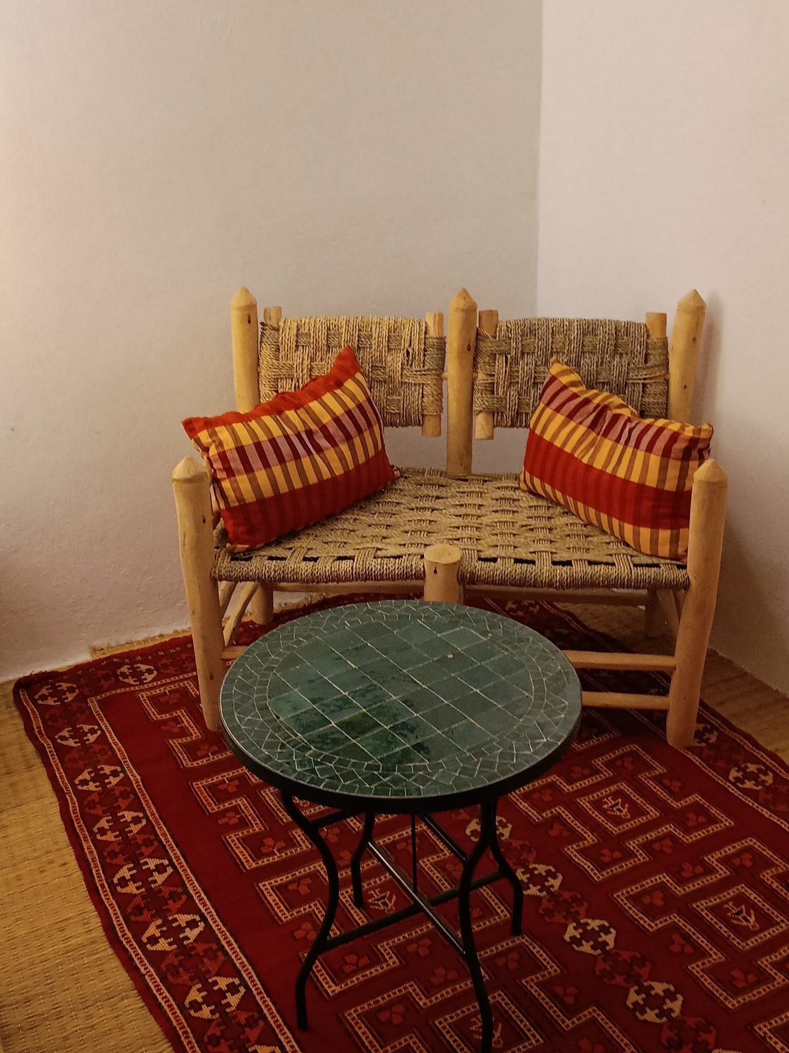 Salon chaleureux aux tapis tissés et banquettes traditionnelles — espace détente